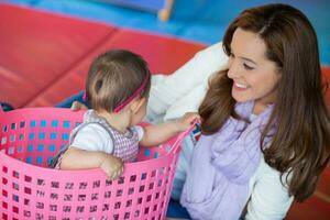 Beautiful ten months baby girl playing with her mom. Early stimulation for toddlers concept. photo