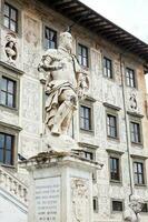 The statue of Cosimo I de Medici in front of Palazzo della Carovana built in 1564 located at the palace in Knights Square in Pisa photo