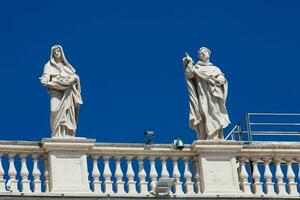 Detail of the statues of saints that crown the colonnades of St. Peter Square built on 1667 on the Vatican City photo