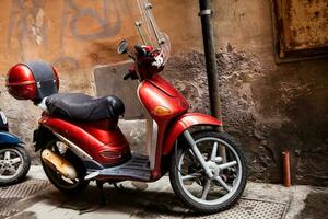 Red vintage scooter parked at Pisa city center photo