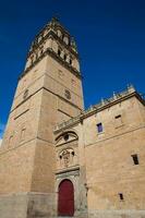 The beautiful bell tower of the Salamanca Cathedral against a blue sky photo