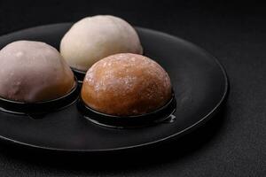 Delicious sweet mochi dessert with toppings on a dark concrete background photo