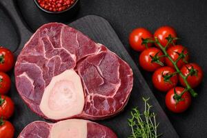 Fresh raw beef steak with bone or ossobuco with salt, spices and herbs photo