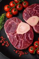 Fresh raw beef steak with bone or ossobuco with salt, spices and herbs photo