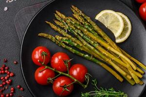 Delicious nutritious breakfast consisting of asparagus, tomatoes, salt, spices and herbs photo