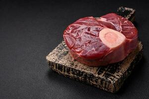 Fresh raw beef steak with bone or ossobuco with salt, spices and herbs photo