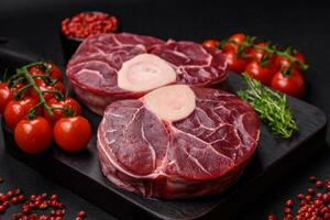 Fresh raw beef steak with bone or ossobuco with salt, spices and herbs photo