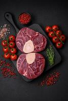 Fresh raw beef steak with bone or ossobuco with salt, spices and herbs photo