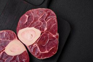 Fresh raw beef steak with bone or ossobuco with salt, spices and herbs photo