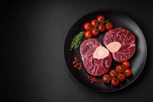 Fresh raw beef steak with bone or ossobuco with salt, spices and herbs photo