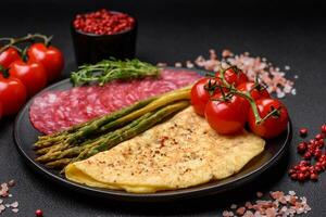 Delicious nutritious breakfast consisting of asparagus, scrambled eggs, salt, spices and herbs photo