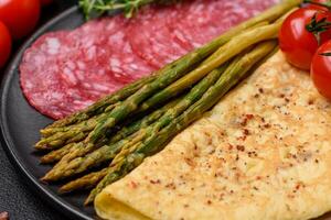 Delicious nutritious breakfast consisting of asparagus, scrambled eggs, salt, spices and herbs photo