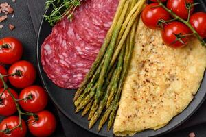 Delicious nutritious breakfast consisting of asparagus, scrambled eggs, salt, spices and herbs photo