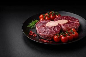 Fresh raw beef steak with bone or ossobuco with salt, spices and herbs photo