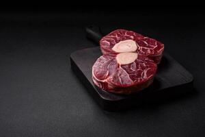 Fresh raw beef steak with bone or ossobuco with salt, spices and herbs photo