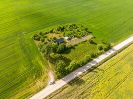 panoramic aerial view of eco village with wooden houses, gravel road, gardens and orchards photo