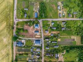 panoramic aerial view of eco village with wooden houses, gravel road, gardens and orchards photo