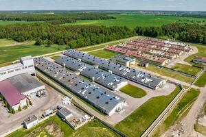 aerial panoramic view over silos and rows of barns, pigsties, chicken coops of huge agro-industrial livestock complex photo