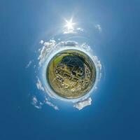 tiny planet in sky with clouds overlooking old town, urban development, historic buildings and crossroads. Transformation of spherical 360 panorama in abstract aerial view. photo