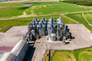 aerial panoramic view on agro-industrial complex with silos and grain drying line for drying cleaning and storage of cereal crops photo