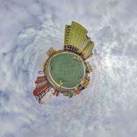 tiny planet in blue sky with clouds in city center near modern skyscrapers in residential complex. Transformation of spherical 360 panorama in abstract aerial view. photo