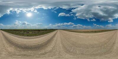 spherical 360 hdri panorama on edge of gravel road with clouds and sun on blue sky in equirectangular seamless projection, use as sky replacement in drone panoramas, game development as sky dome photo