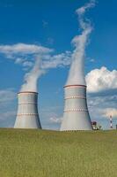 Cooling towers of nuclear power plant against the blue sky photo