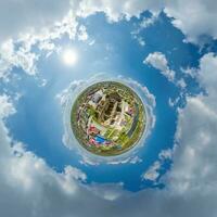 tiny planet in sky with clouds overlooking old town, urban development, historic buildings and crossroads. Transformation of spherical 360 panorama in abstract aerial view. photo