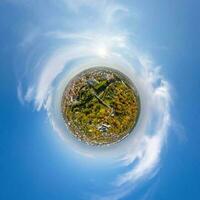 tiny planet in sky with clouds overlooking old town, urban development, historic buildings and crossroads. Transformation of spherical 360 panorama in abstract aerial view. photo