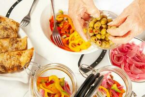 Fish marinade preparation steps. Layering cooked ingredients into a glass bottle to let marinade for one week photo