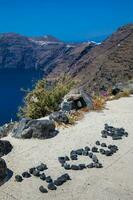 I love you sign made of rocks at the walking trail number 9 between the cities of Fira and Oia in the Santorini Island photo