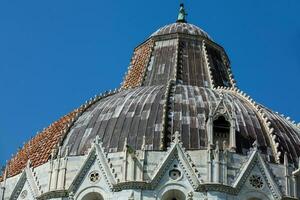 Detail of the cupola of the Pisa Baptistery of St. John against a beautiful blue sky photo