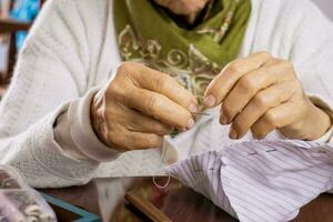 Senior woman sewing a homemade face mask during the Covid 19 pandemic photo