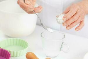 Senior woman preparing dough for a delicious cheese and ham tartlet photo