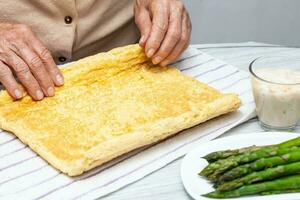 Close up of a senior woman hands stuffing a just baked sponge cake photo