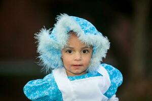 Little girl on grandma costume. Real family having fun while using costumes of the Little red riding hood tale in Halloween. photo