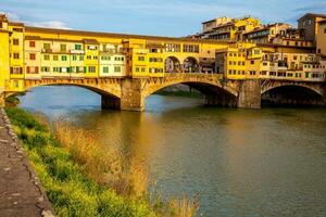 Golden hour at the Ponte Vecchio a medieval stone closed-spandrel segmental arch bridge over the Arno River in Florence photo