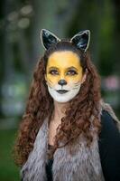 Beautiful young woman wearing a wolf costume. Real family having fun while using costumes of the Little red riding hood tale in Halloween. photo