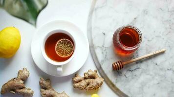 a cup of tea with honey, lemon and ginger on a marble table video