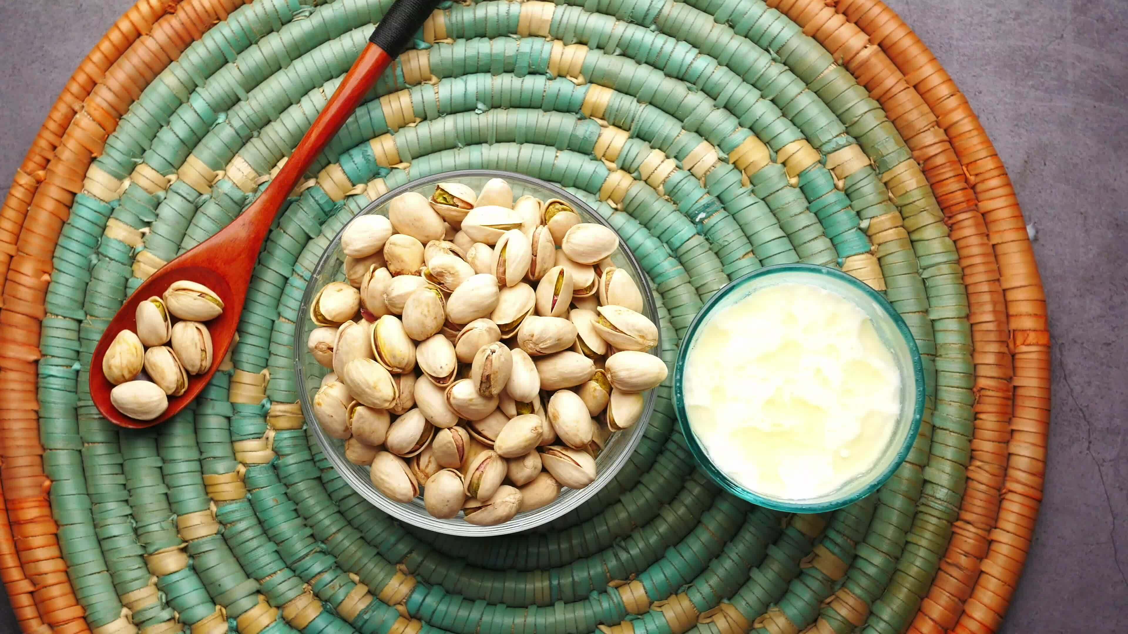 pistachio nuts and yogurt on a woven mat 26368648 Stock Video at Vecteezy