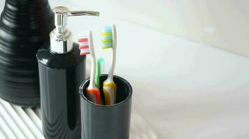 a black toothbrush holder with three toothbrushes video