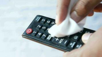 a person is wiping the remote control with a cloth video