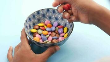 a person holding a bowl of colorful candy video