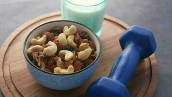 a bowl of nuts and a blue dumbbell video