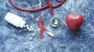 ein Herz, ein Stethoskop, rot Band, und Tabletten auf ein Blau Oberfläche video