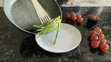 The process of cooking fresh green sprigs of delicious healthy crispy asparagus with salt and spices as part of a vegetarian dish video