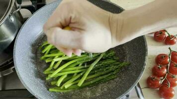 The process of cooking fresh green sprigs of delicious healthy crispy asparagus with salt and spices as part of a vegetarian dish video