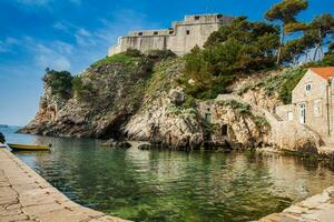 Dubrovnik West Pier and the medieval Fort Lovrijenac located on the western wall of the city photo