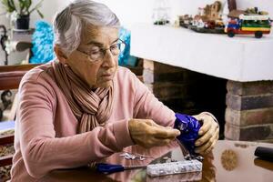 Senior woman at home arranging her prescription drugs into a weekly pill organizer photo