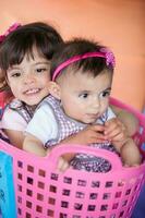 Beautiful small girl playing with her ten months baby girl sister. Early stimulation for toddlers and children concept. photo